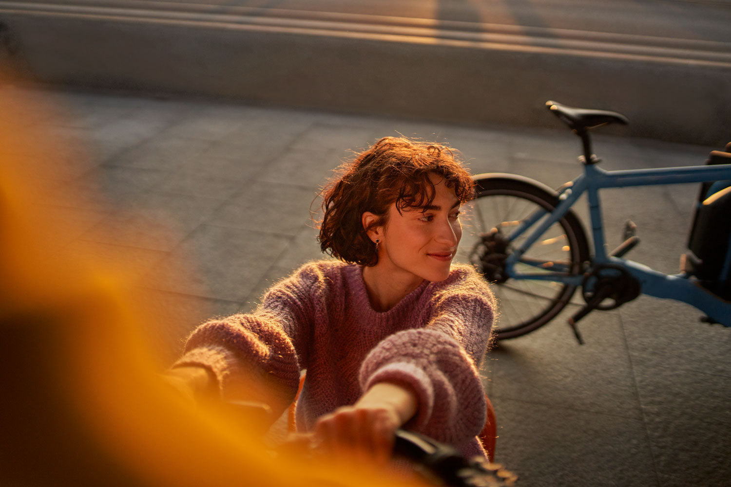 Eine junge Frau ist mit einem Fahrrad draußen im freien.